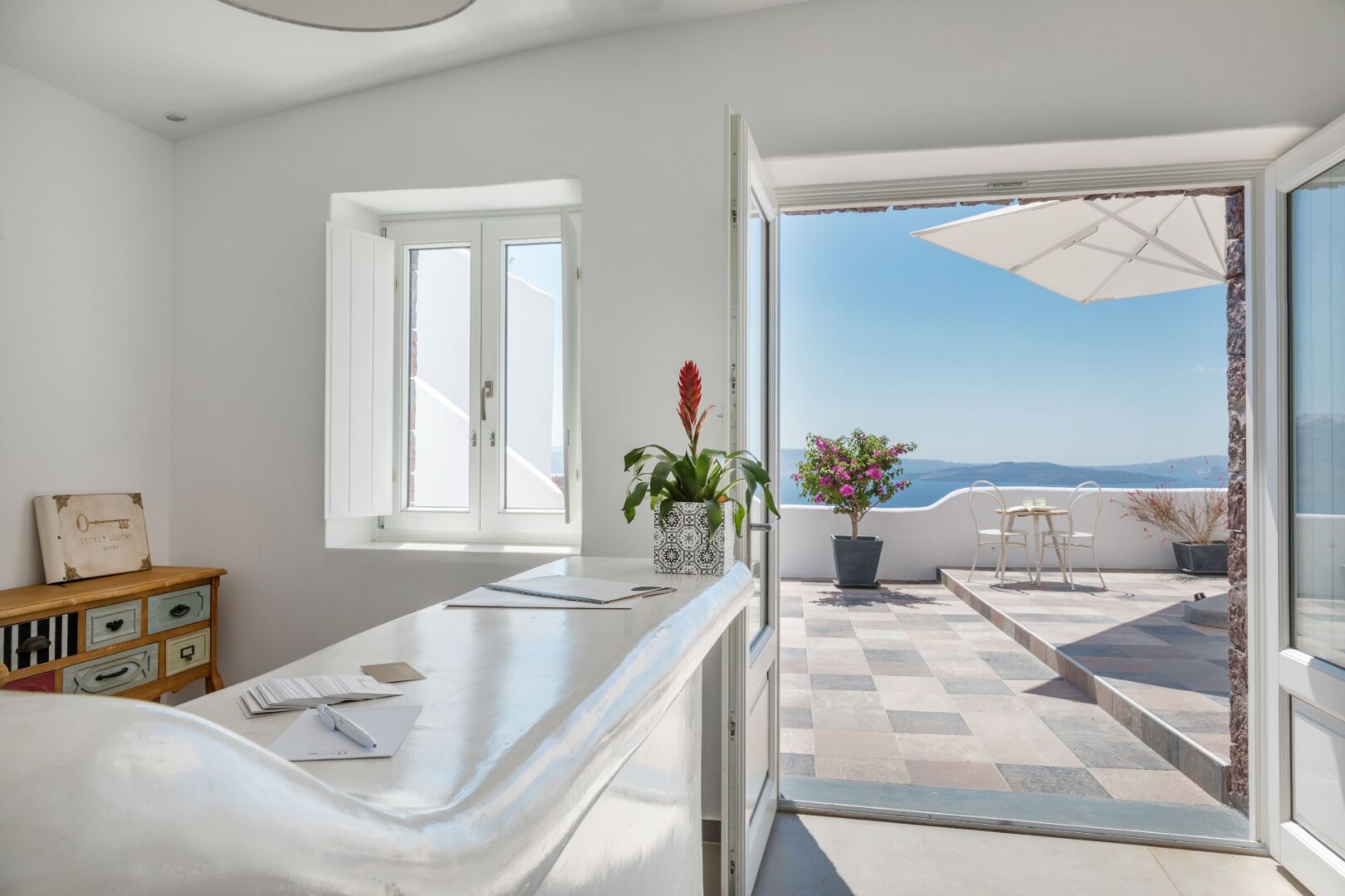 Reception desk and counter, opening out to a terrace at Secret Legend Suites by Secret Hotels.